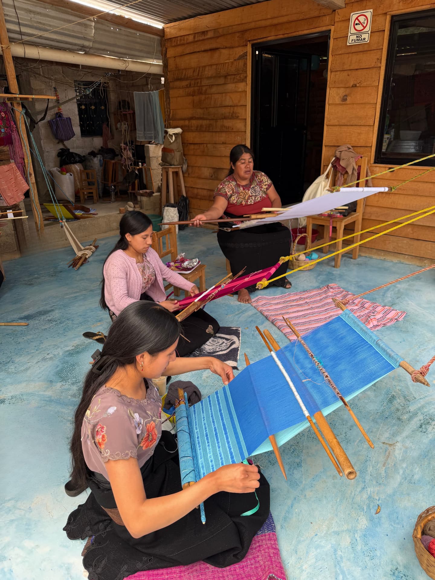 Weavers at work on backstrap looms