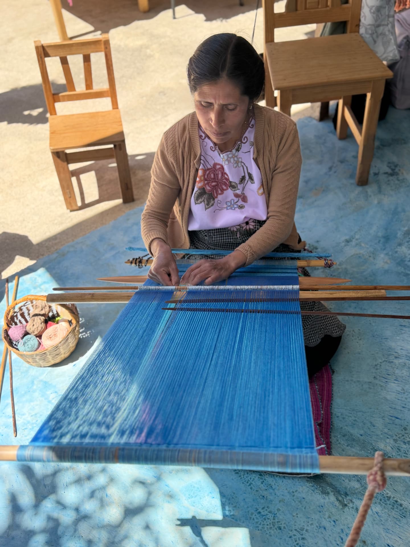 Hand-embroidered huipiles and rebozos hanging at a textile market in San Cristóbal de las Casas